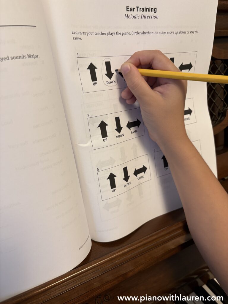 Beginner piano student practicing ear training and listening skills during a piano lesson.